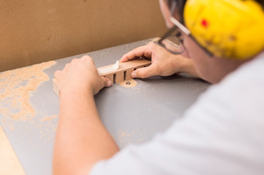 Junger Mann arbeitet mit Holz in der Schreinerei